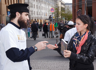 Berlin  Deutschland  Mann ueberreicht einer Passantin den Koran und diskutiert mit ihr