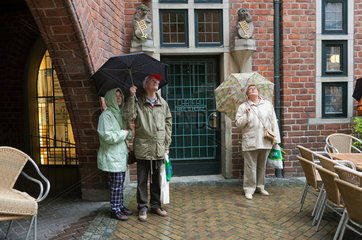Bremen  Deutschland  Touristen bei Regen in der Boettcherstrasse