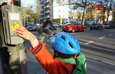 Berlin  Deutschland  Kind drueckt den Knopf an einer Fussgaengerampel