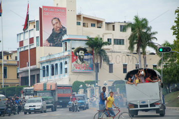 Santiago de Cuba  Kuba  Stadtverkehr  im Hintergrund die Parteizentrale der PCC