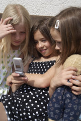 Riedlingen  Deutschland  3 Maedchen spielen mit einem Handy
