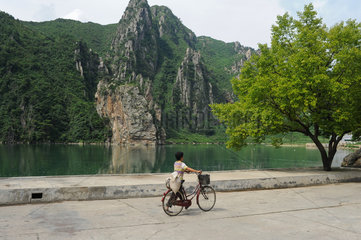 Sinpyong  Nordkorea  eine Frau geht an einem See entlang