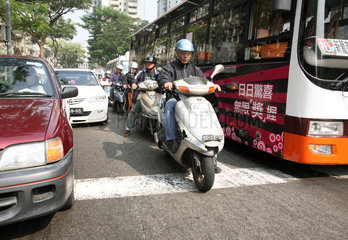 Macau  China  Motorradfahrer und Autofahrer halten an einer Ampel