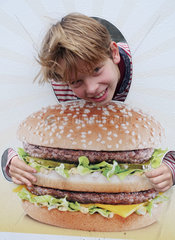 Utrecht  Niederlande  Junge steckt seinen Kopf durch eine Fotowand mit dem Bild eines Burgers