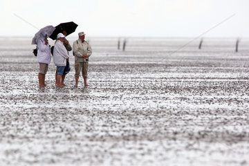 Cuxhaven  Deutschland  Menschen bei Regenwetter im Wattenmeer