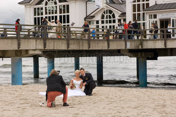 Sellin  Deutschland  Hochzeitspaar laesst sich vor der Seebruecke fotografieren