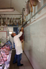 Orvieto  Italien  Fleischer haengt einen Schinken auf einen Haken