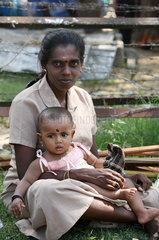 Batticaloa  Sri Lanka  eine Mutter mit Kind wartet auf den Abtransport mit Bussen