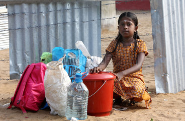 Batticaloa  Sri Lanka  Maedchen mit Sachen am Zaun