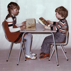 Eisenach  DDR  Kindergartenkinder sitzen an einem Tisch und schauen sich Buecher an