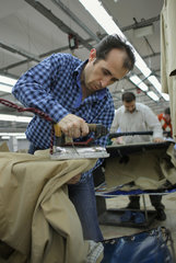 Istanbul  Tuerkei  Mitarbeiter beim Buegeln von Maenteln in einer Textilfabrik auf
