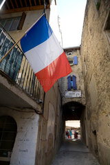 Dieulefit  Frankreich  eine Seitenstrasse mit einer franzoesischen Nationalfahne