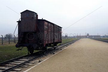 Auschwitz  Polen  Gueterwaggon vor dem Torhaus des Konzentrationslager Auschwitz-Birkenau