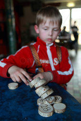 Goehren-Lebbin  Deutschland  Junge spielt mit nummerierten Holzscheiben