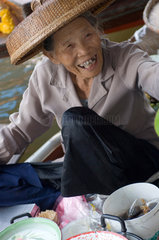 Damnoen Saduak  Thailand  eine Haendlerin verkauft Essen auf dem schwimmenden Markt