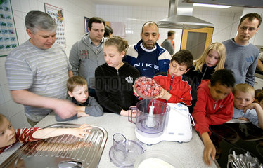 Norderney  Deutschland  Kinder und Vaeter beim gemeinsamen Kochen in der Lehrkueche