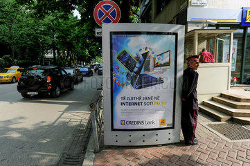 Tirana  Albanien  ein Wachmann lehnt an einer Werbetafel