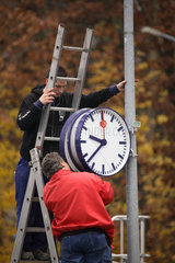 Berlin  Deutschland  Zwei Maenner befestigen eine Uhr der DB