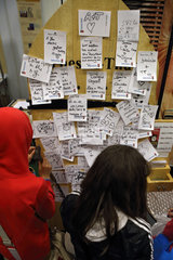 Berlin  Deutschland  Kinder nageln auf der Jugendmesse YOU beschriebene Zettel an eine Holzwand