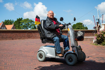 Greetsiel  Deutschland  ein Mann unterwegs mit einem Elektromobil