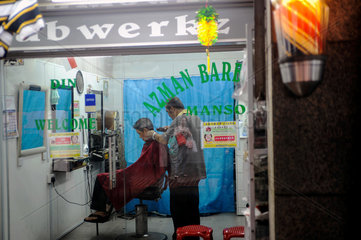 Singapur  Republik Singapur  Frisoer schneidet einem Kunden die Haare