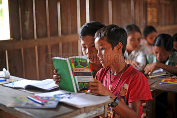 Phum Chikha  Kambodscha  zwei Schueler teilen sich ein Lehrbuch