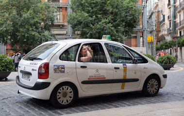 Palma  Mallorca  Spanien  Touristin fotografiert Sehenswuerdigkeiten aus dem Taxi heraus