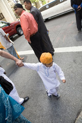 New York City  USA  kleiner Junge in indischer Tracht zerrt an der Hand seines Vaters