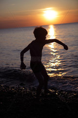 Kaegsdorf  Deutschland  Silhouette  ein Kind spielt bei Sonnenuntergang am Strand