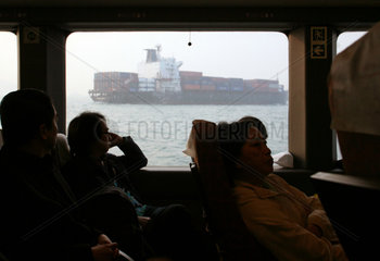 Macau  China  Blick aus dem Fenster einer Faehre auf ein Containerschiff