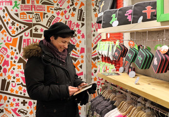 Berlin  Deutschland  Frau schaut sich Waren in einem Ampelmann-Shop an