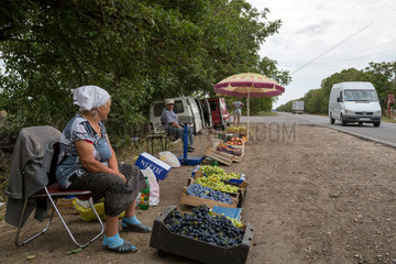 Republik Moldau  Baeuerin verkauft Weintrauben an einer Landstrasse