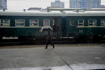 Pjoengjang  Nordkorea  Mann mit Regenschirm am Bahnsteig des Bahnhofs