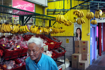 Singapur  Republik Singapur  Bananen haengen vor einem Lebensmittelgeschaeft
