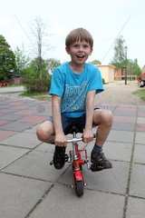 Zossen  Deutschland  Junge faehrt auf einem Mini-Fahrrad