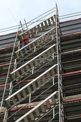 Zuerich  Schweiz  Bauarbeiter geht eine Treppe an einem Baugeruest hinauf