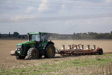 Wilmersdorf  Traktor zieht Pflug ueber Feld