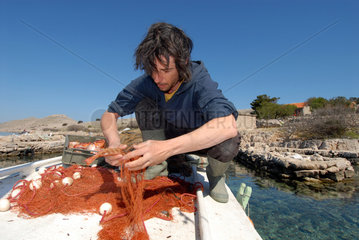 Sibenik  Kroatien  ein Fischer auf seinem Boot auf einer kleinen Insel vor Sibenik