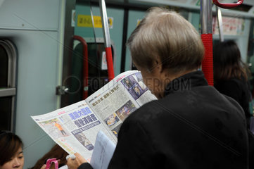 Hong Kong  China  Fahrgast in einer U-Bahn beim Zeitung lesen
