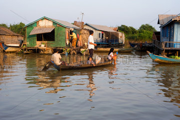 Chong Kneas  Kambodscha  Vater mit seinen Kindern im Longtailboot vor einem Hausboot