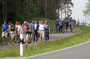 Schoenefeld  Deutschland  Menschen laufen eine Landstrasse entlang