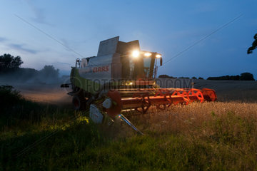 Penzlin  Deutschland  Maehdrescher einer Genossenschaft bei naechtlicher Weizenernte