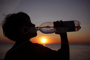 Kaegsdorf  Deutschland  Silhouette  Kind trinkt Wasser aus einer Flasche