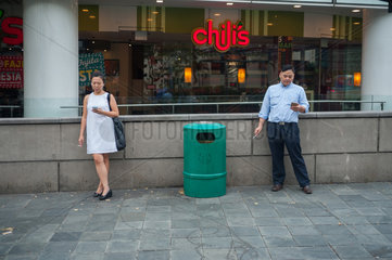 Singapur  Republik Singapur  Menschen rauchen vor einem Einkaufszentrum