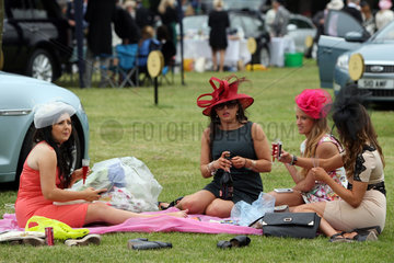 Ascot  Grossbritannien  elegant gekleidete Frauen mit Hut machen ein Picknick