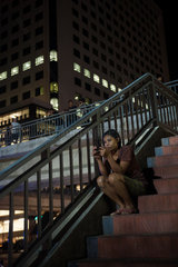 Yangon  Myanmar  Frau sitzt auf den Stufen einer Fussgaengerbruecke
