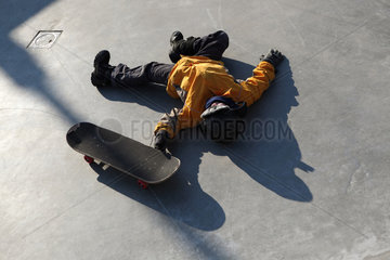 Utrecht  Niederlande  Junge mit Skateboard liegt auf dem Boden