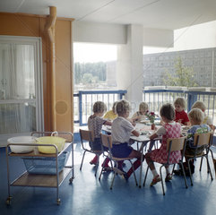 Berlin  DDR  Kindergartenkinder sitzen zum Essen auf dem Balkon an einem Tisch