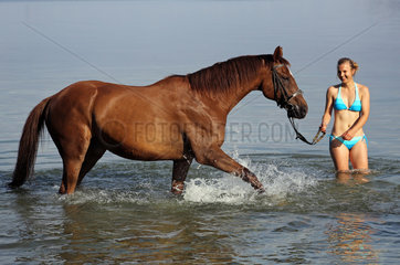 Schwerin  Deutschland  junge Frau steht mit ihrem Pferd im Schweriner See