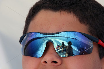 Capodimonte  Italien  Menschen auf einem Motorboot spiegeln sich in der Sonnenbrille eines Jungen